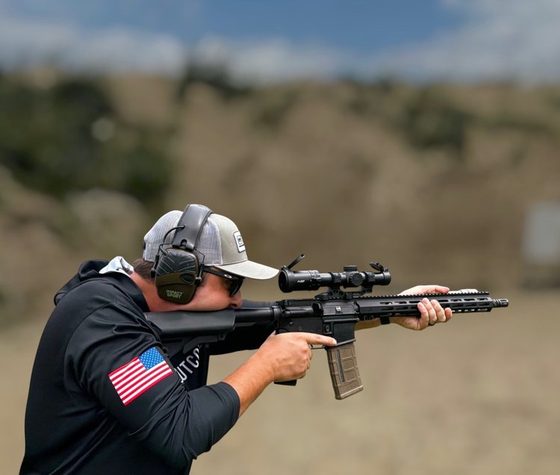 Andy Kester aiming a rifle with an optic