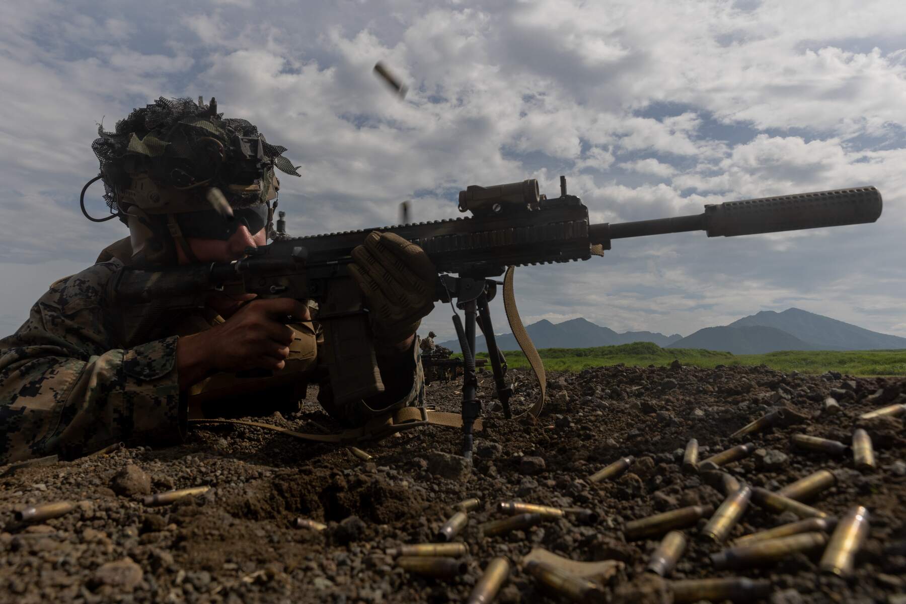 A Marine firing from the prone position, spent brass in the air