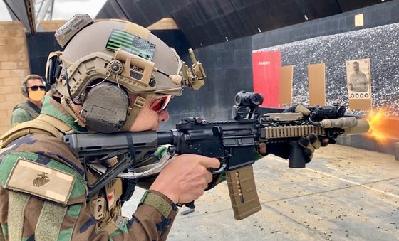 Will Robinson firing a rifle in a helmet and ear protection